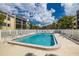 Community pool with lounge chairs and white fence at 14130 Rosemary Ln # 2208, Largo, FL 33774