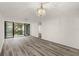 Bright living room with sliding glass doors to balcony and wood-look floors at 14130 Rosemary Ln # 2208, Largo, FL 33774