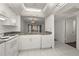 Kitchen with white cabinets, granite counters, and a view to living room at 14130 Rosemary Ln # 2208, Largo, FL 33774