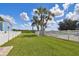 Landscaped backyard with a pool and a white fence at 8107 Sierra Manor Ln, Tampa, FL 33635