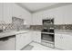 White kitchen with stainless steel appliances and granite countertops at 4221 W Spruce St # 1424, Tampa, FL 33607