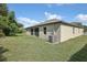 Side view of a single-story house with a large backyard and AC unit at 4013 Chadwick Ave, Spring Hill, FL 34609