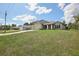 House exterior view showing a two-car garage and large front yard at 4013 Chadwick Ave, Spring Hill, FL 34609