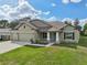 New construction home with a 3-car garage and landscaped lawn at 4013 Chadwick Ave, Spring Hill, FL 34609