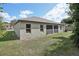 Rear view of a single-story house with a large backyard and screened windows at 4013 Chadwick Ave, Spring Hill, FL 34609