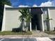 Exterior view of a light green condo building with stairs and palm trees at 13300 Walsingham Rd # 52, Largo, FL 33774