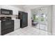 Bright kitchen features black appliances and white cabinets, and a view into a sunroom at 2316 Lake Woodberry Cir, Brandon, FL 33510