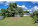 Large backyard featuring a detached garage and outbuilding with grassy area at 5829 12Th St, Zephyrhills, FL 33542