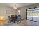 Modern dining room with round table and four blue chairs, near sliding doors to patio at 9308 Pebble Creek Dr, Tampa, FL 33647