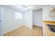 Galley kitchen with tile floor, white cabinets and a laundry closet at 2650 Countryside Blvd # F110, Clearwater, FL 33761