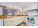 Kitchen with light wood cabinets, tile floor, and view into adjacent dining area at 2650 Countryside Blvd # F110, Clearwater, FL 33761