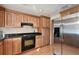 Kitchen boasts wood cabinets, granite countertops, and a black stove at 10213 Newport Cir, Tampa, FL 33612