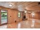 Large living room with wood paneling, a stone fireplace, and access to the backyard at 10213 Newport Cir, Tampa, FL 33612
