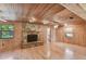 Spacious living room with hardwood floors, wood walls, and a stone fireplace at 10213 Newport Cir, Tampa, FL 33612