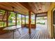 Covered screened porch features a wooden deck, ceiling fan, and table at 10213 Newport Cir, Tampa, FL 33612