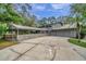 Long driveway leading to a two-car garage with covered carport and fenced dog run at 655 Appaloosa Rd, Tarpon Springs, FL 34688