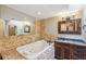 Relaxing bathroom with a large jacuzzi tub and stone tile at 655 Appaloosa Rd, Tarpon Springs, FL 34688