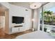Modern bedroom with hardwood floors, large TV, and private balcony access at 777 N Ashley Dr # 806, Tampa, FL 33602