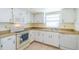 Clean kitchen with white cabinets, a dishwasher and a stove at 2535 Lancaster Dr # 2535, Sun City Center, FL 33573