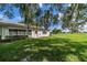 Backyard view with green grass and oak trees at 2535 Lancaster Dr # 2535, Sun City Center, FL 33573