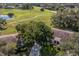 Aerial view of a house and surrounding landscape, showing a large tree and a pond at 2535 Lancaster Dr # 2535, Sun City Center, FL 33573