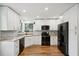 Modern kitchen with white cabinets and black appliances at 2990 Longbrooke Way, Clearwater, FL 33760