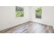 Bright bedroom features wood-look floors and two windows offering natural light at 6907 N 20Th St, Tampa, FL 33610