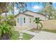 Charming home with a light blue front door, complemented by landscaped stone pathway and vibrant tropical plants at 6907 N 20Th St, Tampa, FL 33610