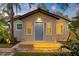 Charming home's front exterior with step lighting, blue door, and stone landscaping for evening appeal at 6907 N 20Th St, Tampa, FL 33610