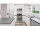 Well-lit kitchen with stainless steel appliances, countertops, and white cabinets at 6907 N 20Th St, Tampa, FL 33610