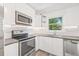 Modern kitchen featuring stainless steel appliances, and sleek white cabinetry at 6907 N 20Th St, Tampa, FL 33610