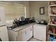 Kitchen features white cabinets and a granite countertop at 1528 Stevensons Dr, Clearwater, FL 33755