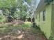 Side yard with mature trees and unkempt landscaping at 1528 Stevensons Dr, Clearwater, FL 33755