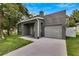 Newly built home with gray exterior, attached garage, and driveway at 2604 N 29Th St, Tampa, FL 33605