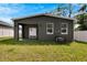 Back exterior view showcasing a covered patio and AC unit at 2604 N 29Th St, Tampa, FL 33605