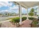 Inviting front porch with brick pavers, white columns, and view of the neighborhood at 5413 Cafrey Pl, Apollo Beach, FL 33572