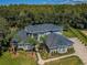 A beautiful aerial view shows a gray two-story home with an attractive front yard and driveway at 180 Keystone Palms Blvd, Tarpon Springs, FL 34688