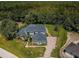 Expansive aerial view of a luxury home featuring lush landscaping and a paver driveway and mature trees at 180 Keystone Palms Blvd, Tarpon Springs, FL 34688