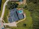 Aerial view of a large house with a screened-in pool, well-maintained lawn, and surrounding trees at 180 Keystone Palms Blvd, Tarpon Springs, FL 34688