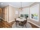 Bright breakfast nook features a modern chandelier and a view of the outdoor pool and lanai at 180 Keystone Palms Blvd, Tarpon Springs, FL 34688