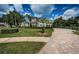 A paver driveway runs along the side of a landscaped lawn with a two-story home at 180 Keystone Palms Blvd, Tarpon Springs, FL 34688