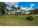 Landscaped front yard featuring a two story-home, palm trees, and a plush green lawn at 180 Keystone Palms Blvd, Tarpon Springs, FL 34688