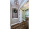 Elegant hallway with wood floors, decorative lighting, and arched doorway to the main bedroom at 180 Keystone Palms Blvd, Tarpon Springs, FL 34688