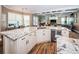 Open kitchen with custom cabinetry, center island with sink, and view into the living room at 180 Keystone Palms Blvd, Tarpon Springs, FL 34688