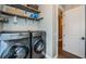 Laundry room featuring modern front-loading washer and dryer, with overhead storage shelves at 180 Keystone Palms Blvd, Tarpon Springs, FL 34688