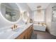 Luxury main bathroom featuring a soaking tub, dual vanities, and modern lighting fixtures at 180 Keystone Palms Blvd, Tarpon Springs, FL 34688