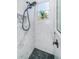 Updated shower with modern fixtures, white subway tile, a mosaic tile insert, and pebble flooring at 180 Keystone Palms Blvd, Tarpon Springs, FL 34688