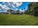 Large grassy backyard with home view, trees, and partial fence in background at 180 Keystone Palms Blvd, Tarpon Springs, FL 34688