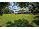 Green lawn with home view, trees, and partial fence in background at 180 Keystone Palms Blvd, Tarpon Springs, FL 34688