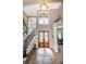 Two-story foyer with hardwood floors, chandelier, and elegant staircase at 180 Keystone Palms Blvd, Tarpon Springs, FL 34688